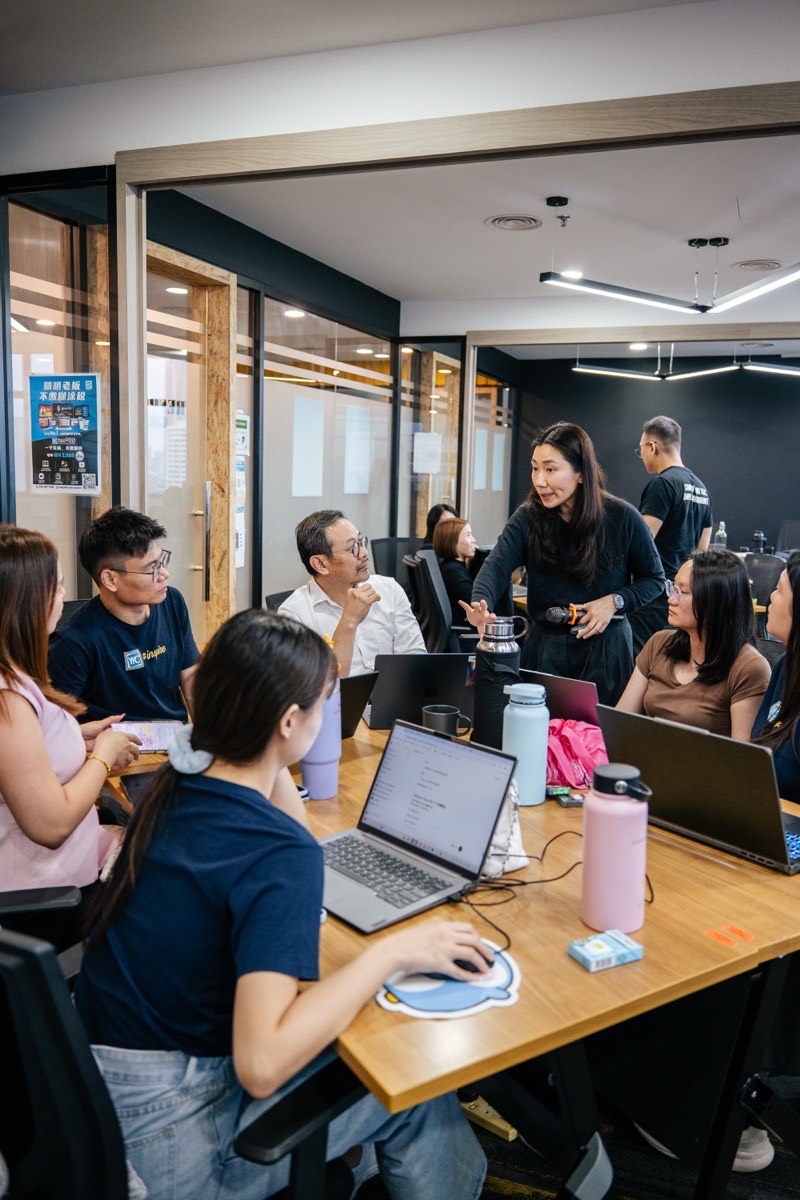 Michelle standing with a team, guiding them through a hands-on exercise